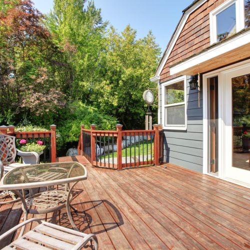 House,Exterior,With,Large,Open,Deck,And,Outdoor,Furniture.